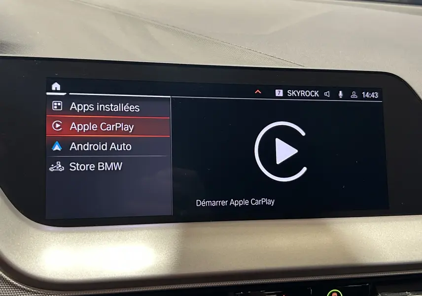 Écran central tactile de la BMW Série 1 16d 2023 affichant le menu Apple CarPlay en surbrillance.