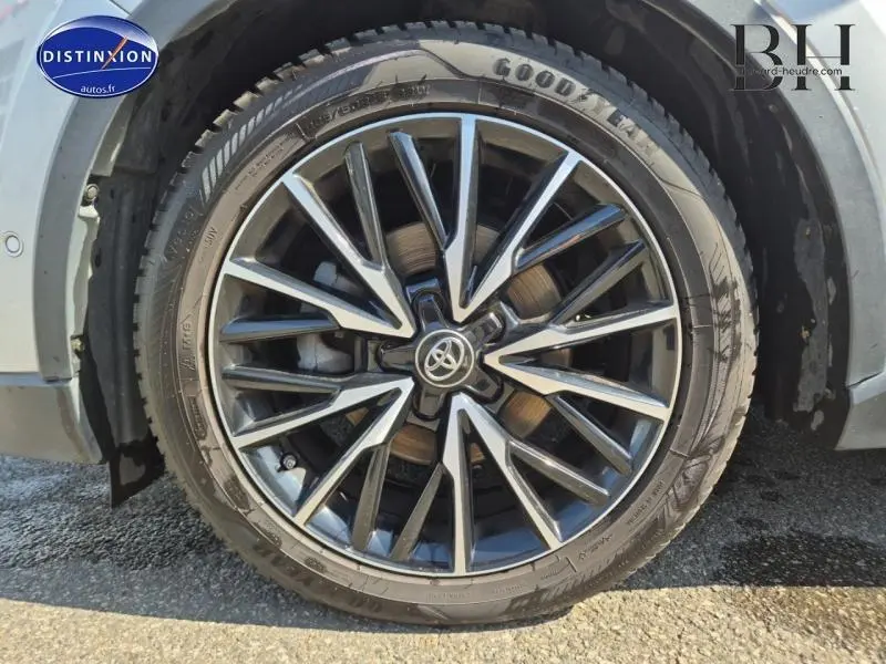 Gros plan sur la jante alliage noire et argentée du Toyota C-HR gris aluminium, mettant en valeur le logo Toyota central.