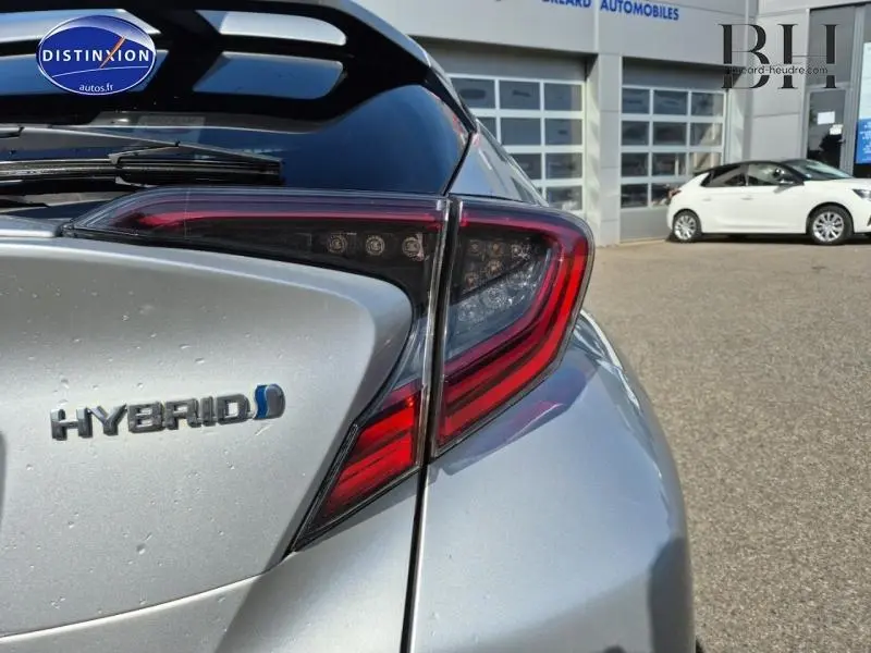 Gros plan sur le feu arrière droit gris aluminium du Toyota C-HR 122h Distinctive hybride 2019 avec logo Hybrid visible.