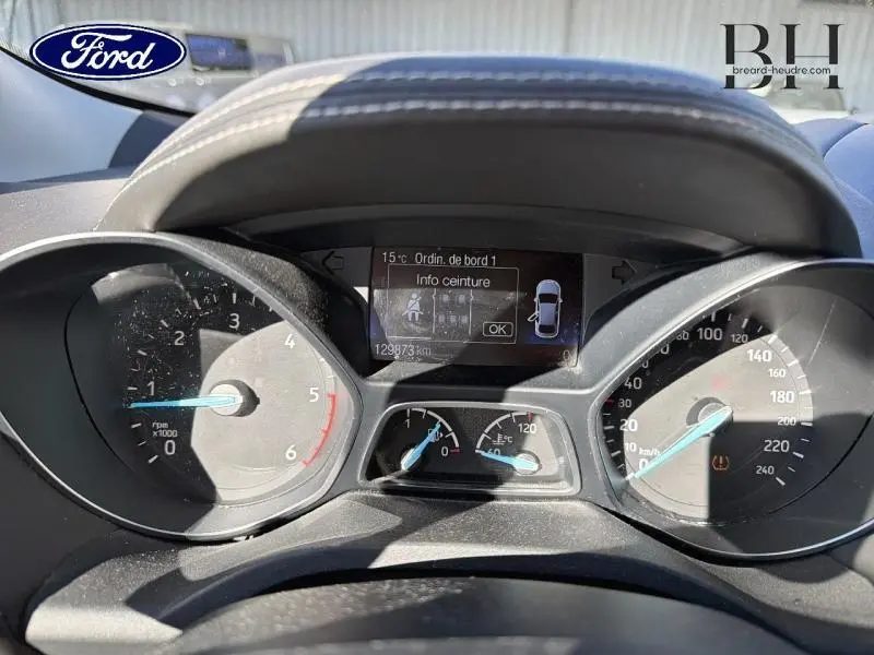 Vue rapprochée du tableau de bord du Ford Kuga blanc, affichant compte-tours, vitesse et écran multifonction.