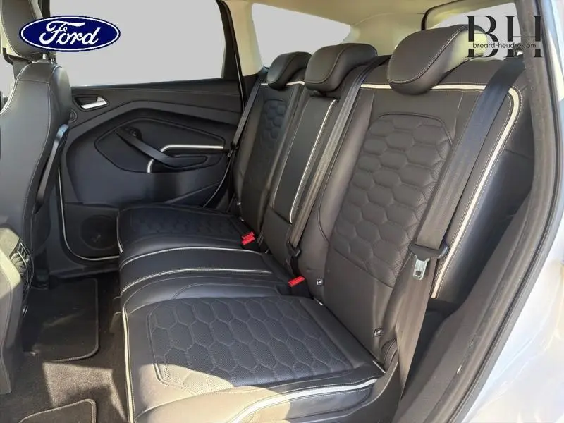 Vue latérale droite de l'intérieur arrière du Ford Kuga 2017 avec sièges en cuir noir au design hexagonal et surpiqûres blanches.