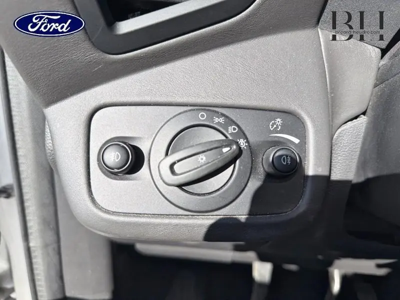 Gros plan sur le bouton de commande des phares du Ford Kuga 2017, tableau de bord noir mat.