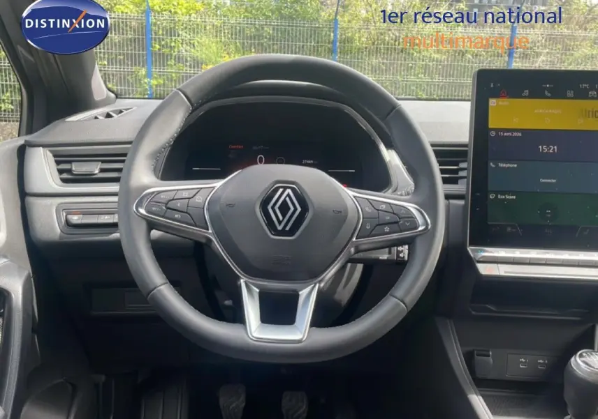 Vue frontale de l'intérieur du Renault Captur 2025, volant cuir noir avec commandes intégrées et écran tactile central.