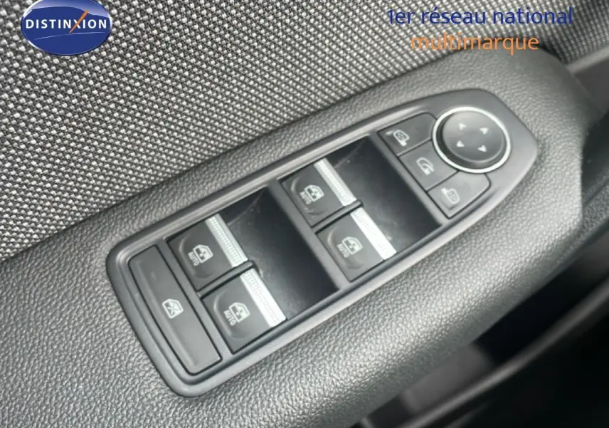 Gros plan sur les commandes des vitres électriques et rétroviseurs du côté conducteur du Renault Captur 2025 gris cassiopée métal.