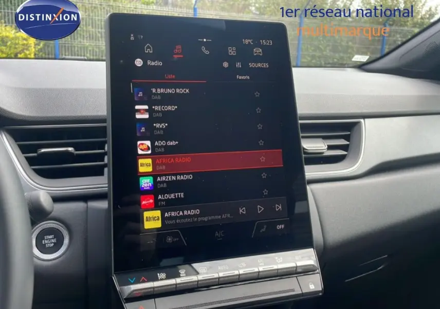 Vue intérieure du tableau de bord du Renault Captur 2025, écran tactile central affichant les stations radio, avec finition gris cassiopée métal.