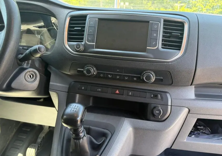 Vue rapprochée de l’intérieur du Peugeot Expert Fourgon blanc 2019, montrant la console centrale avec boîte manuelle et écran tactile.