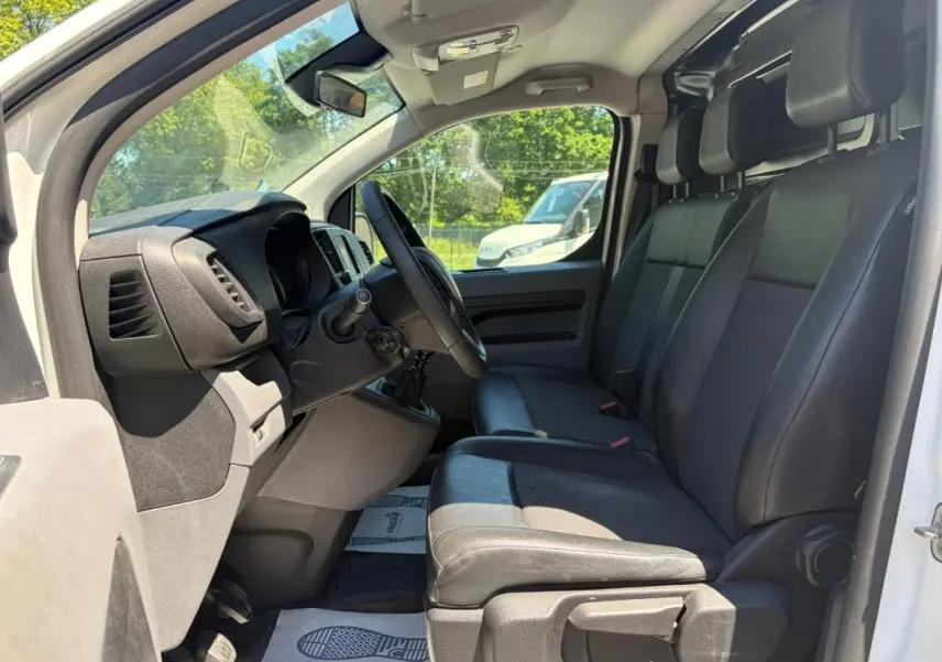 Vue intérieure côté conducteur du Peugeot Expert Fourgon blanc 2019, montrant les sièges en cuir et le volant multifonctions.