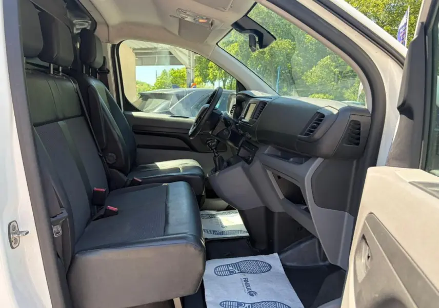 Intérieur avant droit du Peugeot Expert Fourgon blanc 2019, montrant sièges en cuir, tableau de bord et volant multifonctions.