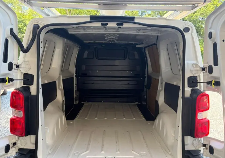Vue arrière ouverte du Peugeot Expert Fourgon blanc 2019 montrant l’espace de chargement vide et les portes battantes ouvertes.