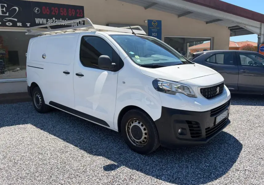 Peugeot Expert Fourgon blanc en 3/4 avant droit avec galerie de toit et pare-chocs noirs visibles.