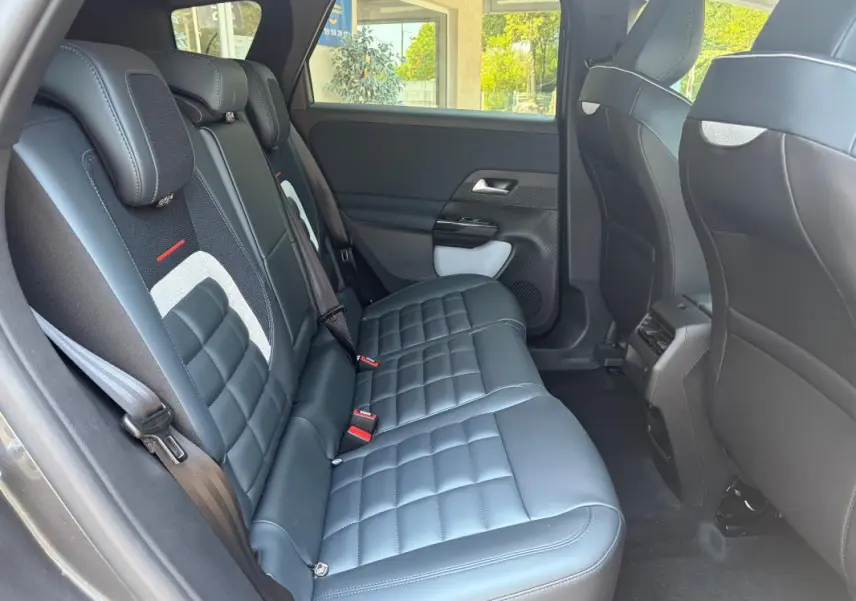 Vue intérieure côté gauche de la banquette arrière en cuir noir du Citroën C5 Aircross gris avec appuie-têtes et ceintures visibles.