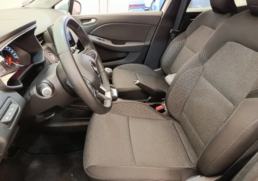 Vue intérieure côté conducteur de la Renault Clio Business TCe 100 2021 avec sièges gris et volant cuir multifonctions.