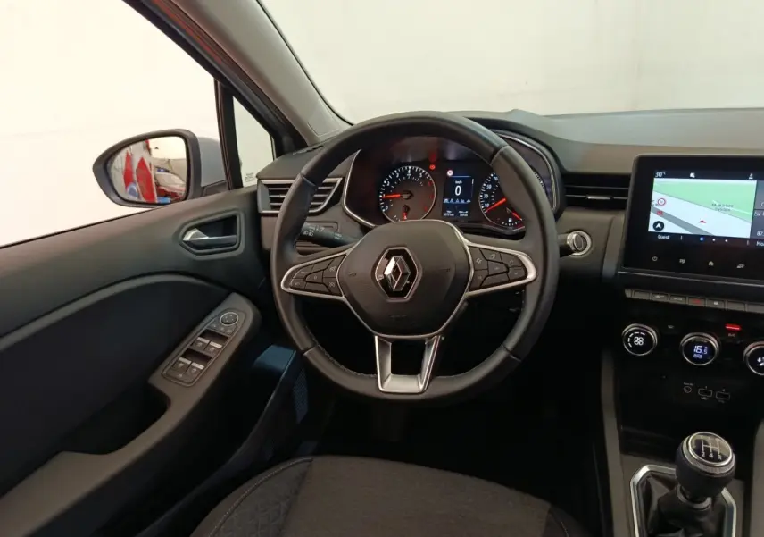 Vue intérieure centrée sur le volant cuir multifonctions et tableau de bord avec écran tactile de la Renault Clio gris clair.