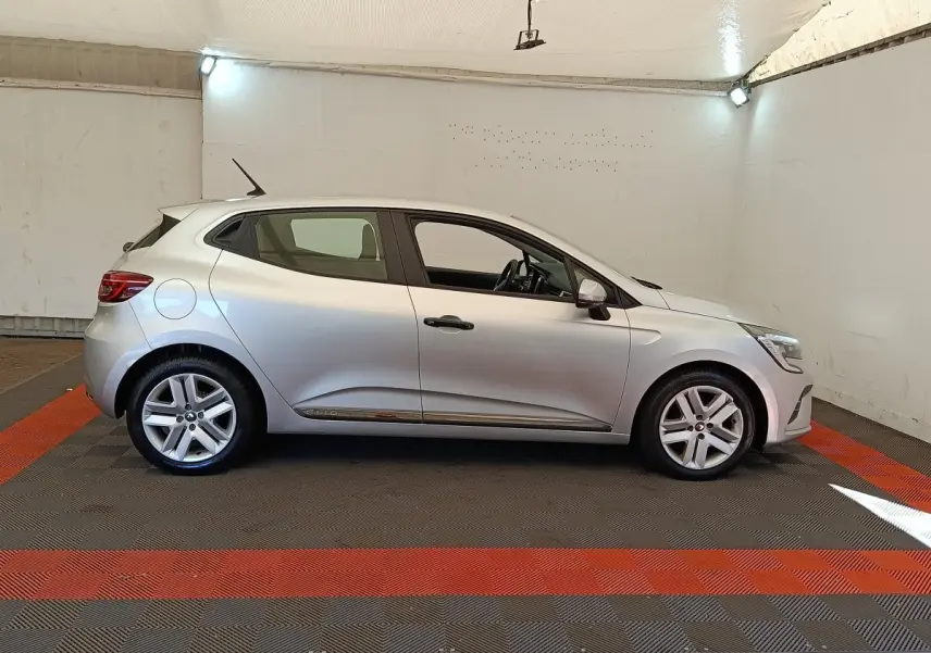Profil droit d'une Renault Clio Business TCe 100 gris clair, avec jantes alliage et poignées de porte noires.