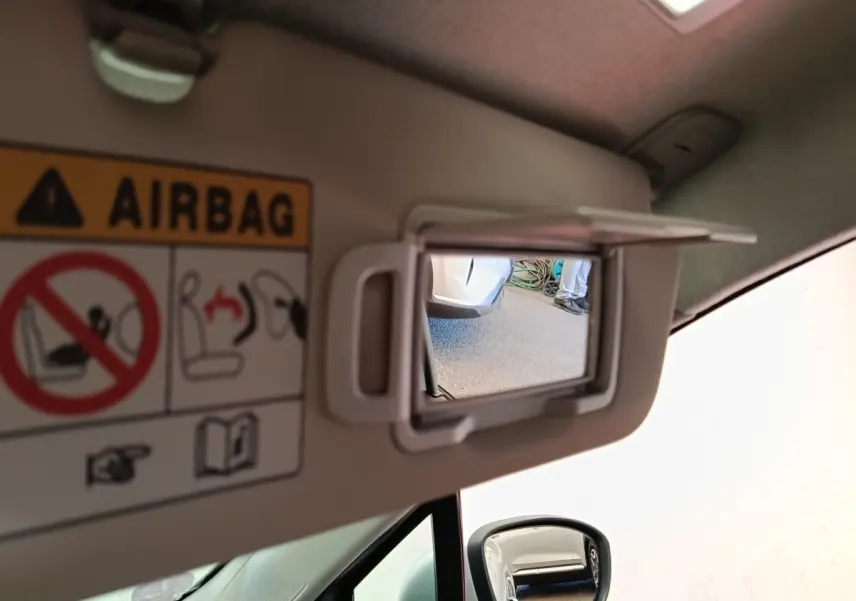 Miroir de courtoisie ouvert sur pare-soleil côté conducteur d’une Renault Clio Business gris clair, intérieur beige.