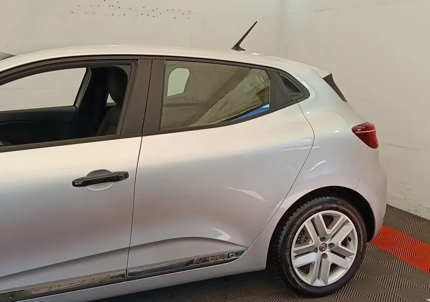 Profil côté gauche de la Renault Clio Business TCe 100 gris clair, avec jante alliage et poignées de porte chromées.