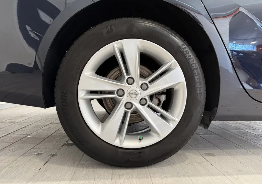 Gros plan sur la roue avant droite d'une Opel Insignia Sports Tourer bleu lune marine avec jante alliage cinq branches.
