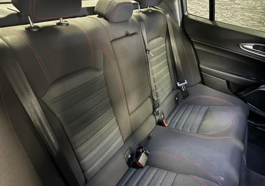Vue intérieure côté droit de la banquette arrière noire avec surpiqûres rouges de l'Alfa Romeo Giulia 2.2 D 2021.