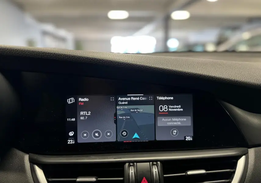 Écran tactile panoramique 8,8" du tableau de bord de l'Alfa Romeo Giulia gris, affichant navigation et radio.