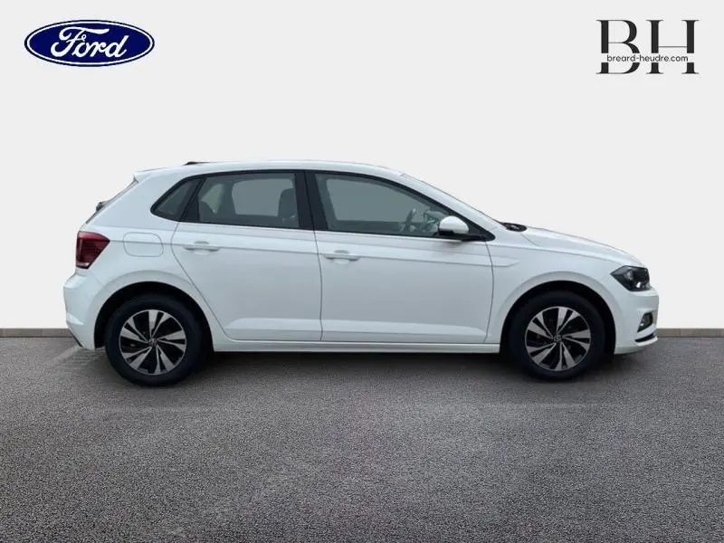 Profil côté gauche d'une Volkswagen Polo blanche, mettant en valeur ses jantes alu et lignes épurées.