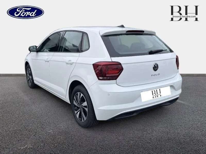 Vue 3/4 arrière droite d'une Volkswagen Polo blanche avec feux arrière rouges et jantes alliage.