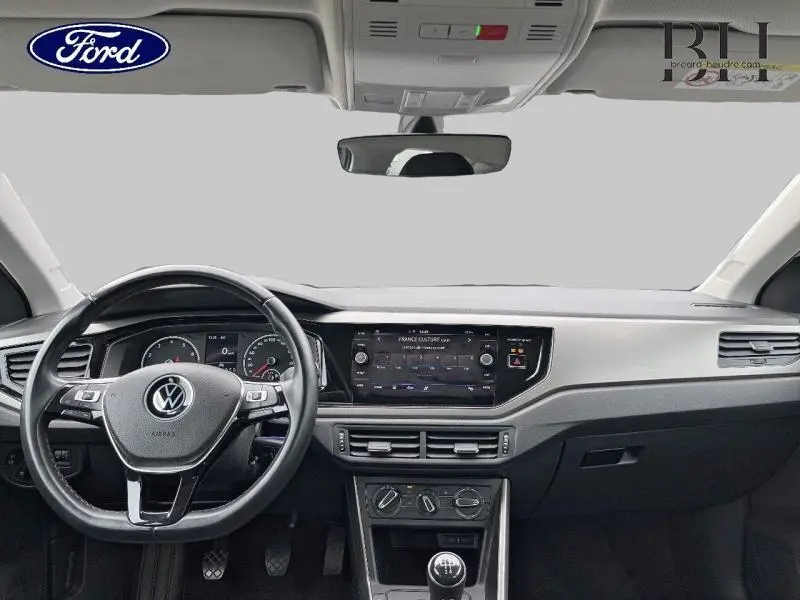 Tableau de bord noir et volant cuir Volkswagen Polo 1.0 TSI vue frontale avec écran tactile et commandes intégrées.