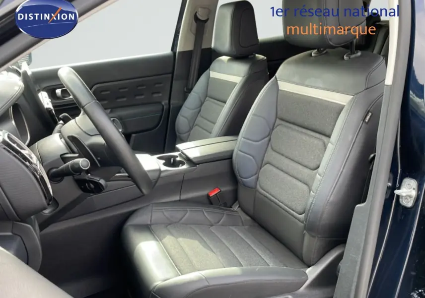 Vue intérieure côté conducteur du Citroën C5 Aircross 2024, sièges en tissu et cuir noir, porte ouverte côté droit.