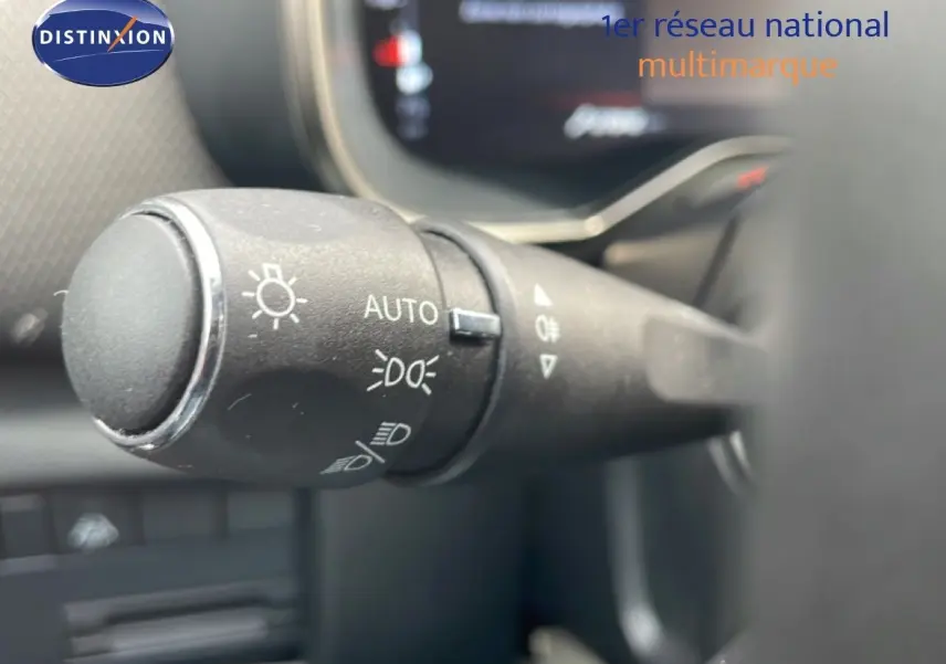 Gros plan sur la commande des phares à gauche du volant dans l'habitacle du Citroën C5 Aircross bleu Eclipse Metal.
