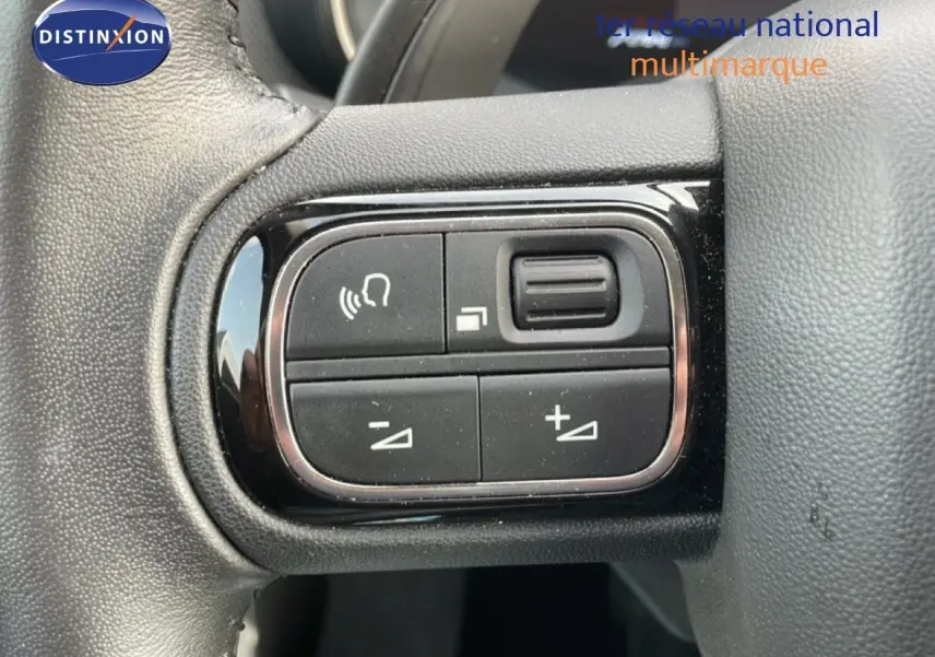 Gros plan sur les commandes noires du volant du Citroën C5 Aircross 2024, finition Bleu Eclipse Metal.
