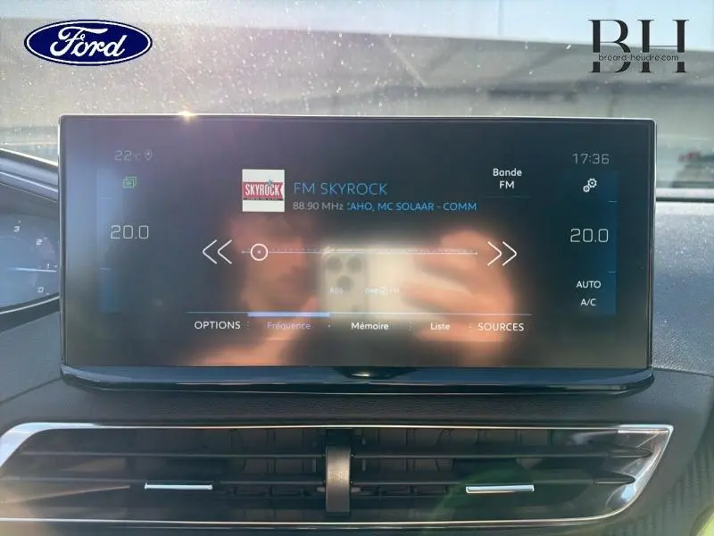 Écran tactile central du Peugeot 5008 2022 en intérieur, affichant la radio FM avec commandes climatisation visibles.