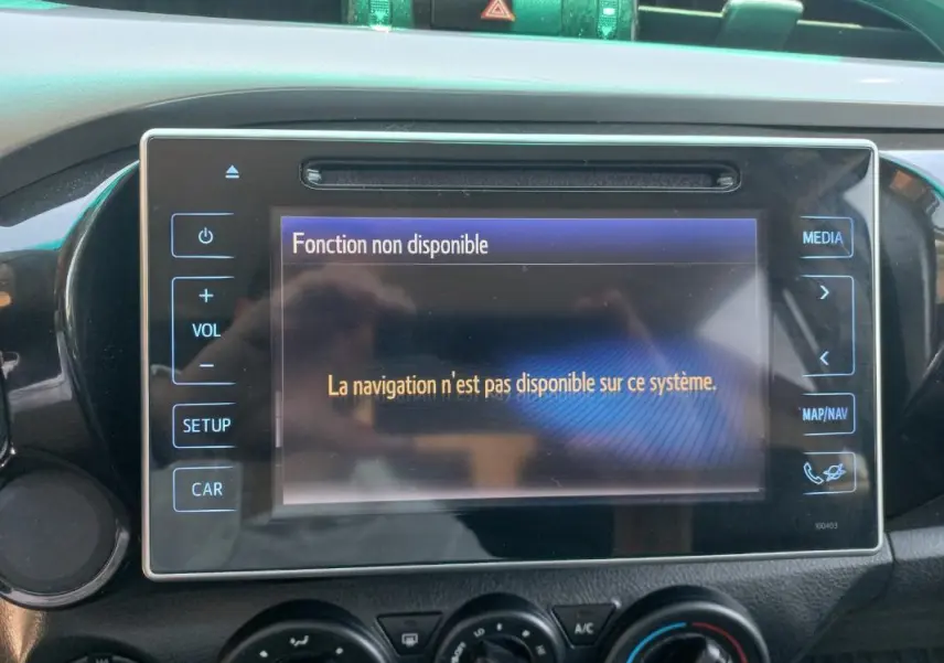 Écran central du Toyota Hilux 2018 affichant un message d'erreur de navigation, entouré des commandes multimédia et climatisation.
