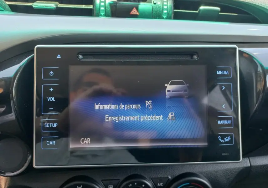 Écran tactile central du Toyota Hilux 2018 affichant les informations de parcours, avec commandes autour en vue frontale.