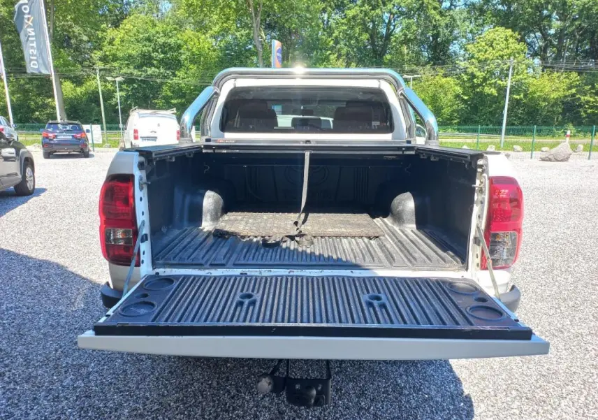 Vue arrière d’un Toyota Hilux 4x4 blanc de 2018 avec benne ouverte et intérieur de caisse visible.