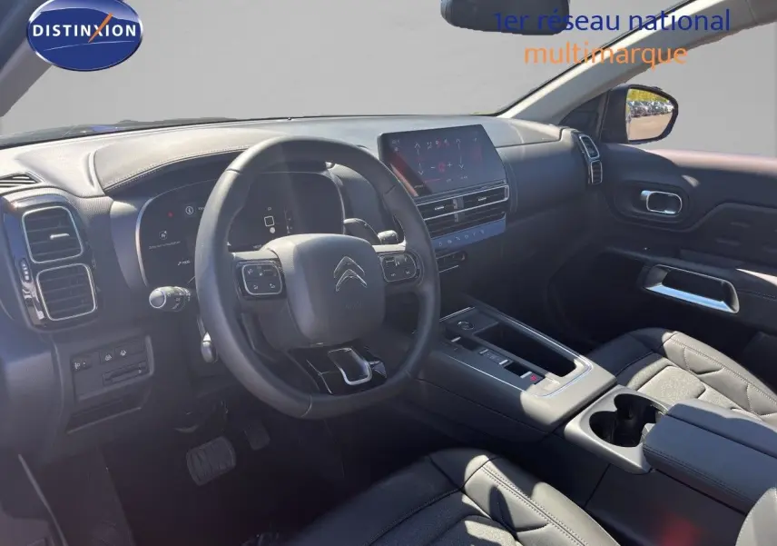 Intérieur avant du Citroën C5 Aircross 2025 noir, vue côté conducteur montrant tableau de bord et volant multifonction.