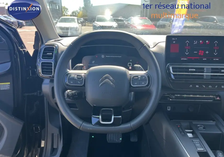 Vue intérieure centrée sur le volant et tableau de bord du Citroën C5 Aircross noir métal, avec écran tactile et commandes intégrées.