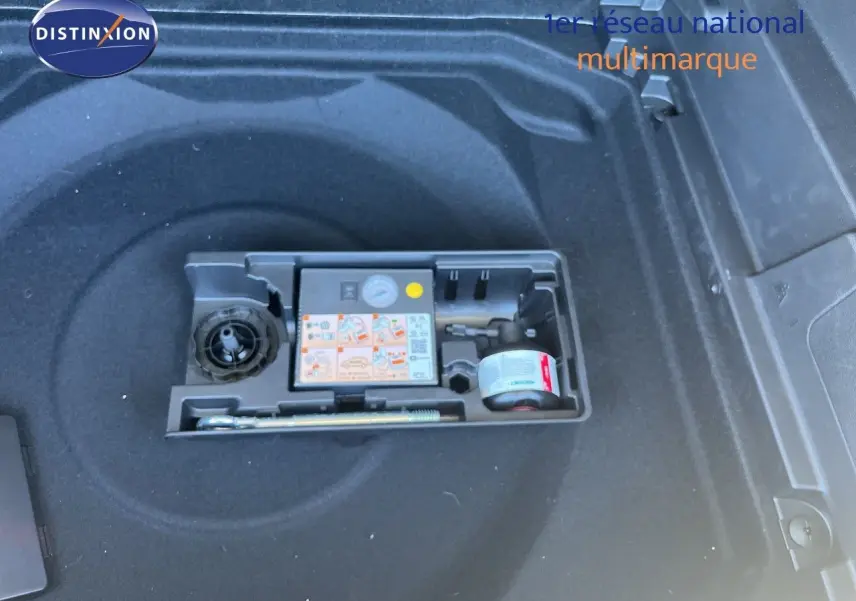 Compartiment de coffre avec kit de réparation pneus dans un Citroën C5 Aircross noir métal, vue plongeante.
