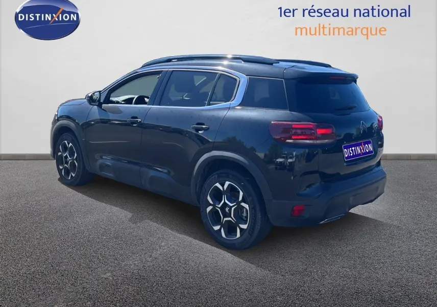 Vue 3/4 arrière droite d'un Citroën C5 Aircross noir métal 2025 avec jantes distinctives et toit noir.