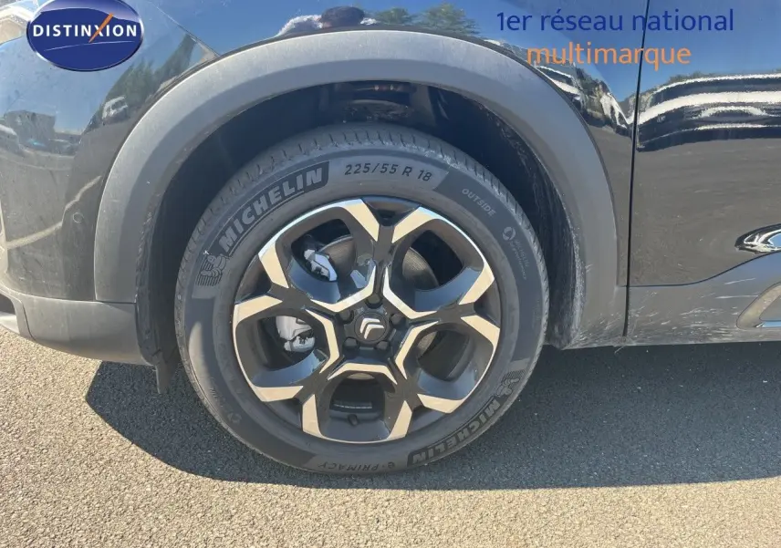 Gros plan sur la roue avant gauche noire métallisée d'un Citroën C5 Aircross 2025 hybride avec jante en alliage distinctive.