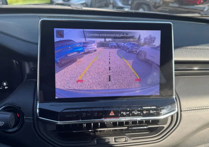 Vue intérieure sur l’écran tactile affichant la caméra de recul du Jeep Compass bleu, avec tableau de bord noir et commandes visibles.