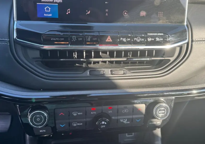 Gros plan sur la console centrale du Jeep Compass bleu 2025, montrant les commandes climatisation et écran tactile.