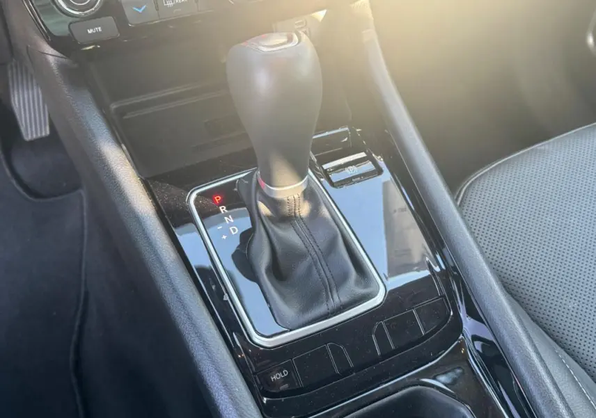Gros plan sur la console centrale noire du Jeep Compass 2025, mettant en valeur le levier de vitesse automatique et le siège gris.