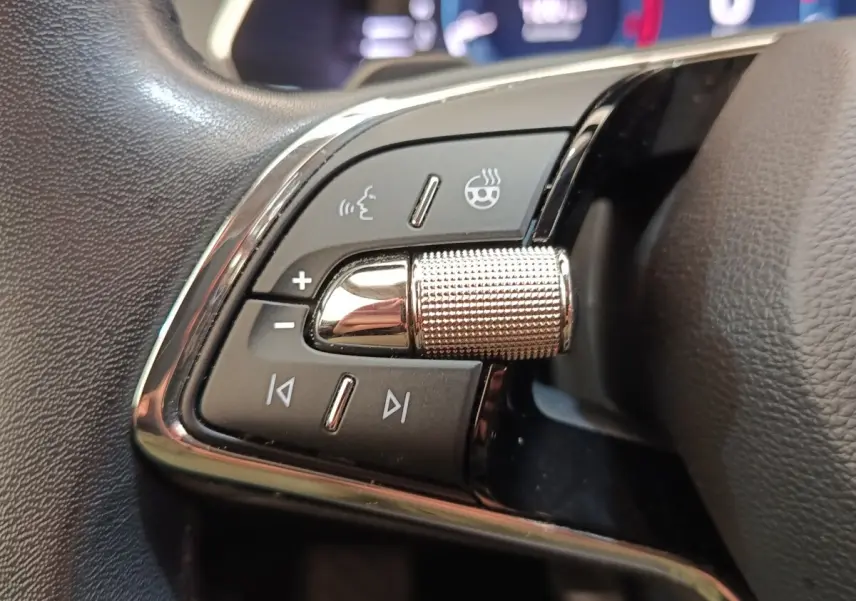 Gros plan sur les commandes en alu et cuir du volant chauffant de la Skoda Octavia 2023, côté gauche.