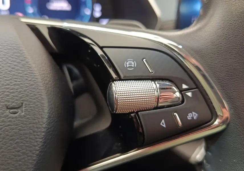 Gros plan sur la molette de commande multifonctions en aluminium du volant cuir noir de la Skoda Octavia 2023.