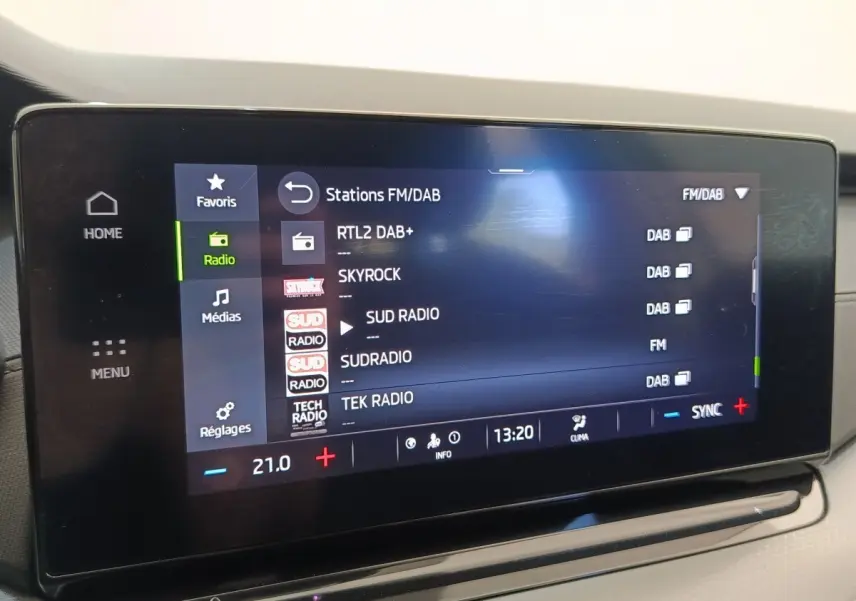 Écran tactile central de la Skoda Octavia 2023 affichant les stations radio FM/DAB, intérieur clair.