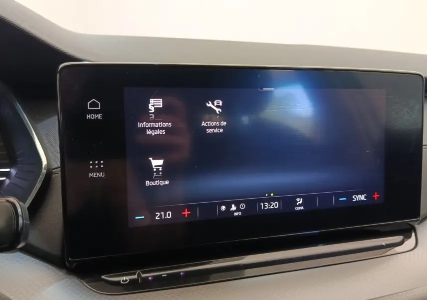 Écran tactile central de la Skoda Octavia 2023 affichant menu et réglages climatisation, intérieur noir.