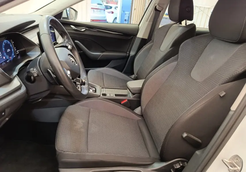 Intérieur de la Skoda Octavia blanc, vue côté conducteur, volant cuir alu multifonctions et sièges tissu gris.