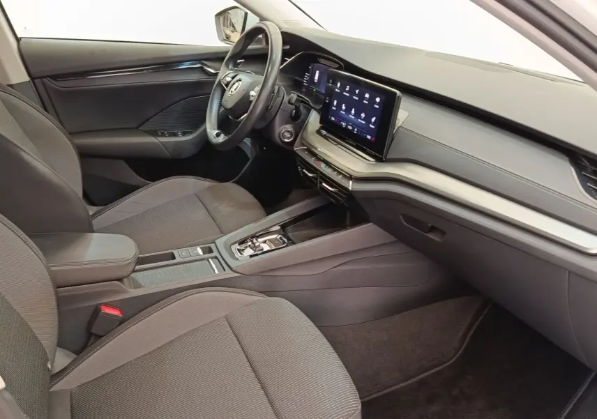 Intérieur de la Skoda Octavia 2023 vu côté conducteur, tableau de bord moderne avec écran tactile et volant multifonctions cuir.