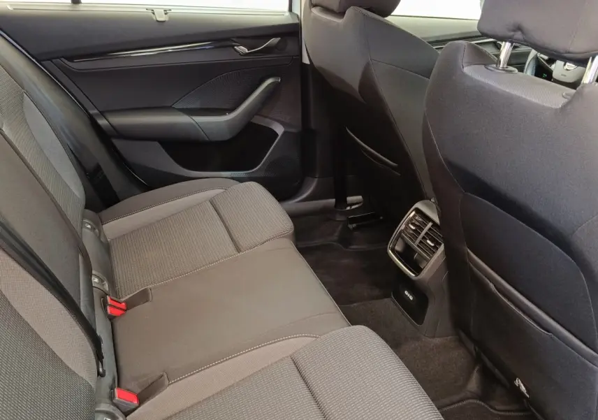 Vue intérieure arrière côté droit de la Skoda Octavia 2023, sièges tissu gris et aérateurs centraux visibles.