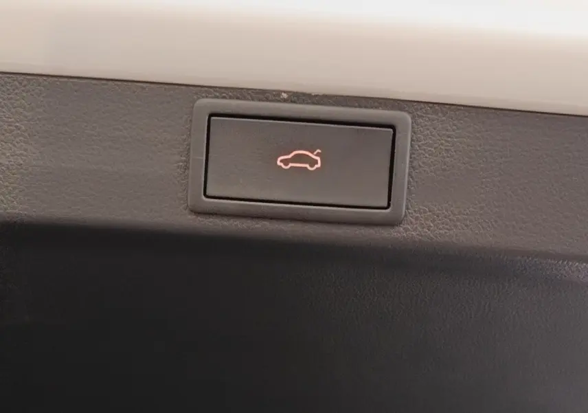 Bouton d'ouverture électrique du coffre sur la partie intérieure d'une Skoda Octavia blanche, version 2023.