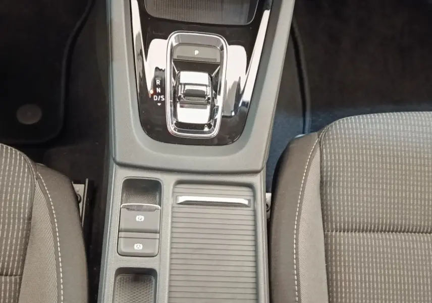 Vue plongeante sur la console centrale noire et la boîte automatique de la Skoda Octavia 2023, sièges gris visibles.